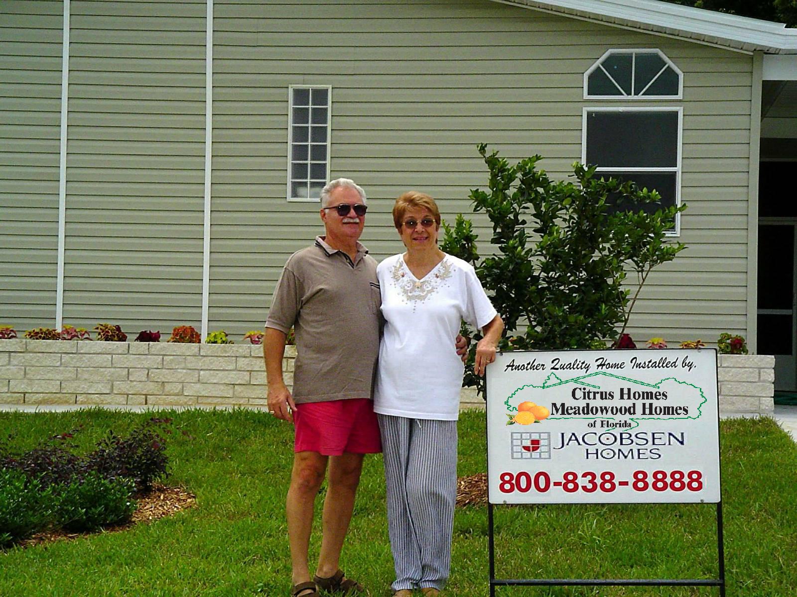 Happy couple in front of their new home