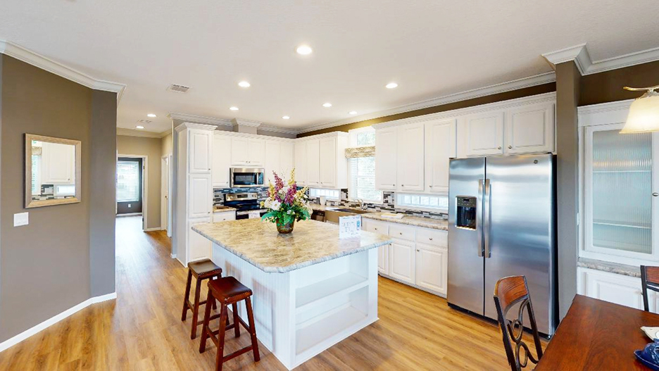 Kitchen with White Cabinets, Stainless Steel Appliances, Euro Range Hood and Island