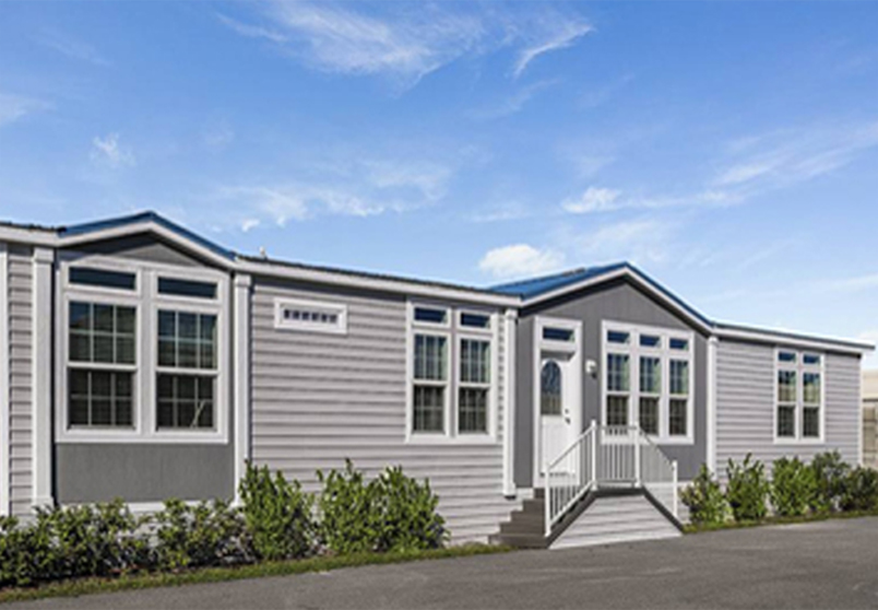 Photo of a double wide manufactured home with grey lap siding with accented dark grey under the two dormers