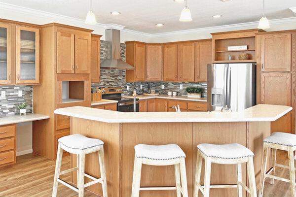 Spacious kitchen with Stratford Oak cabinet, full glass tile back-splash with a Eura vent hood and horseshoe shape island