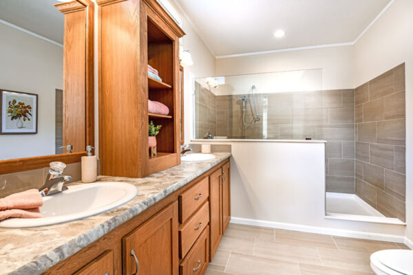 Master Bathroom with a walk-in Statesman Tile Shower. Cabinet are Stratford Oak with double vanities.
