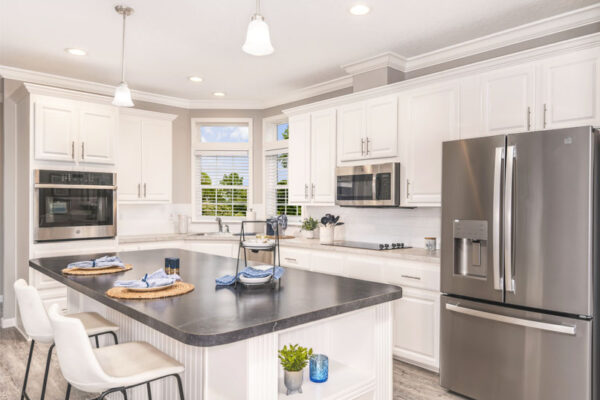 Kitchen with white cabinets and stainless steel appliances and a large island