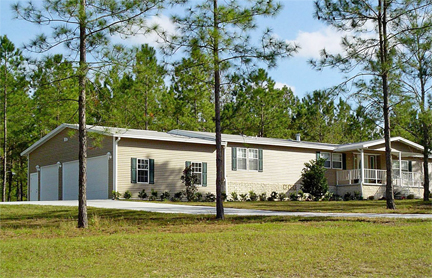 Exterior photo of a home nestled in the woods with a garage and site built porch