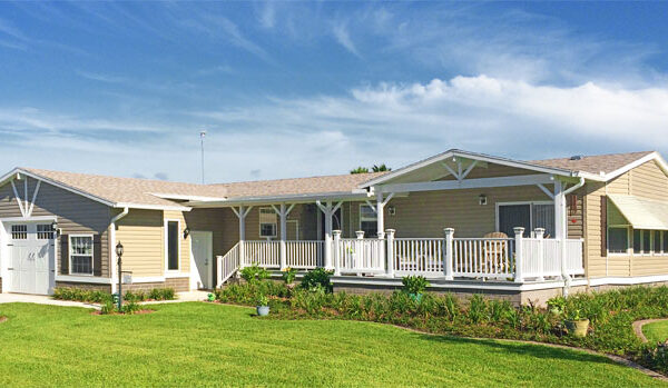 Exterior photo of a home with a site built garage and porch with a large awning over the 6 window bay